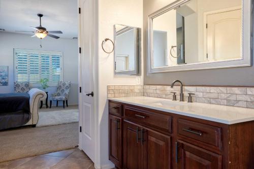 a bathroom with a sink and two mirrors at Modern Paradise: King Bed + EV Charger +Pool Table in Goodyear