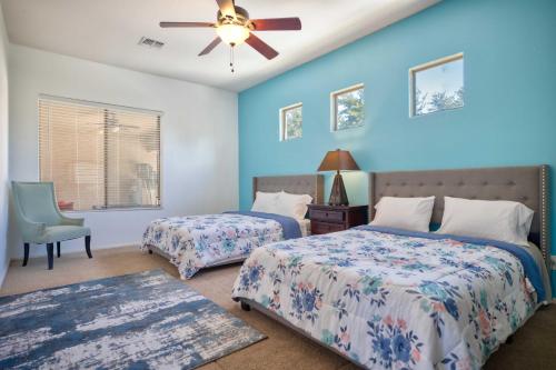 a bedroom with two beds and a ceiling fan at Modern Paradise: King Bed + EV Charger +Pool Table in Goodyear