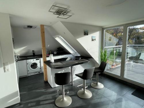 eine Küche mit einer Theke und ein paar Stühlen darin in der Unterkunft Exklusive Wohnung mit Ahrblick 1 und Dachterrasse in Bad Neuenahr-Ahrweiler