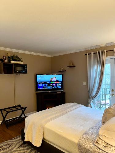 a bedroom with a bed and a flat screen tv at Grafton Lodge in Lake Lure
