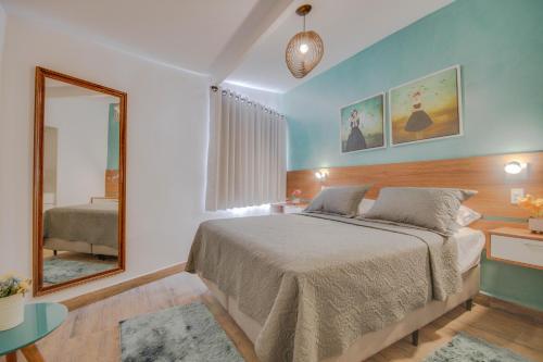 1 dormitorio con 1 cama grande y espejo en Pousada Nanina de Geribá, en Búzios