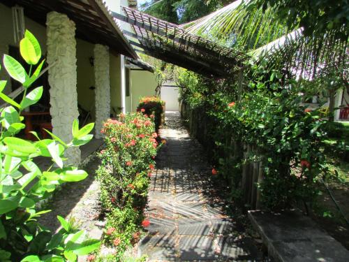 a garden path next to a house with flowers at Pousada Ipitanga IV in Lauro de Freitas