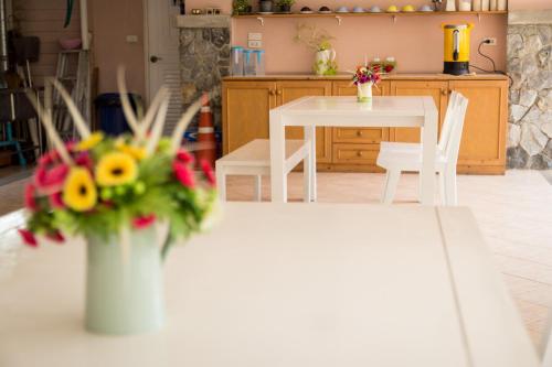 a kitchen with a table with a vase of flowers at Triple Palms House in Chiang Mai