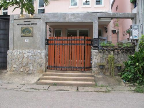 a house with a gate and stairs in front of it at Triple Palms House in Chiang Mai