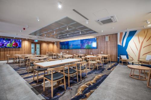 a dining room with tables and chairs and a large screen at Nightcap at Hotel Victor in Victor Harbor