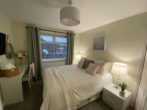 - une chambre avec un lit blanc et une fenêtre dans l'établissement Wharfedale Lodge- Bungalow-3 Bed, 2 bath, Amazing!, à Thornton