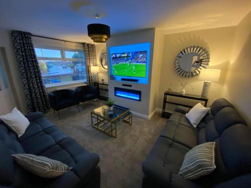 a living room with a couch and a flat screen tv at Wharfedale Lodge- Bungalow-3 Bed, 2 bath, Amazing! in Thornton