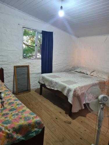 1 dormitorio con cama, espejo y ventilador en Nuestro rincón en San grgorio, a media cuadra de la playa, en San Gregorio de Polanco
