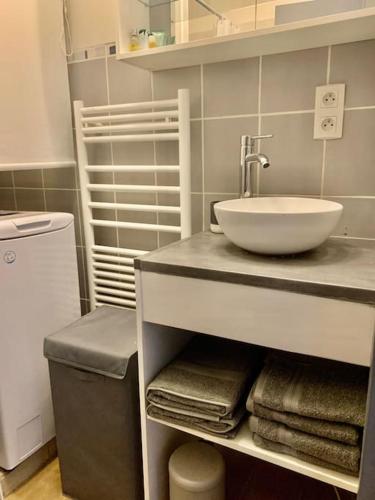 une salle de bain avec un lavabo et une vasque sur un comptoir dans l'établissement Lumineux et cosy, avec parking, 2 mn gare, 2mn Muse, 5mn centre, à Metz