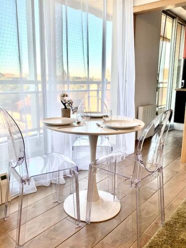 une table et des chaises dans une pièce avec une fenêtre dans l'établissement Lumineux et cosy, avec parking, 2 mn gare, 2mn Muse, 5mn centre, à Metz