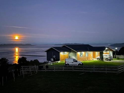 a house with a car parked in front of it at night at Bella casa de campo con panorámica vista al mar in Dalcahue
