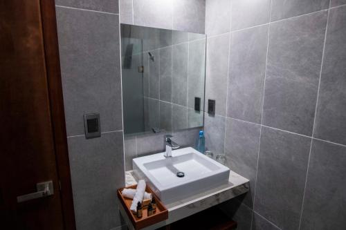a bathroom with a white sink and a mirror at Hotel La Querencia in Río Verde