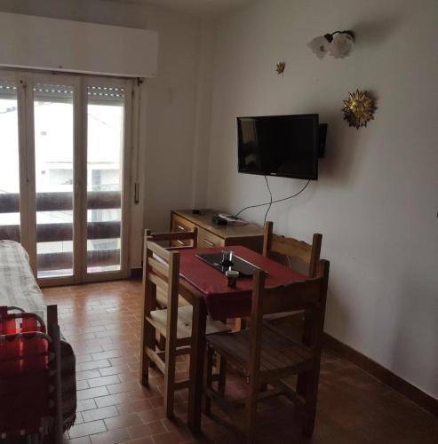 - un salon avec une table, des chaises et une télévision dans l'établissement Edificio Barracuda, à Santa Teresita