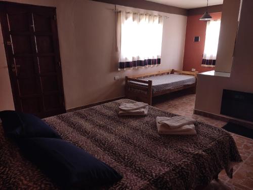 a bedroom with a bed with two towels on it at Retama in Tilcara