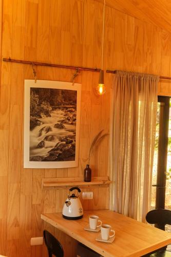 a tea kettle on a wooden table in a room at MA PU LODGE Futaleufu in Futaleufú