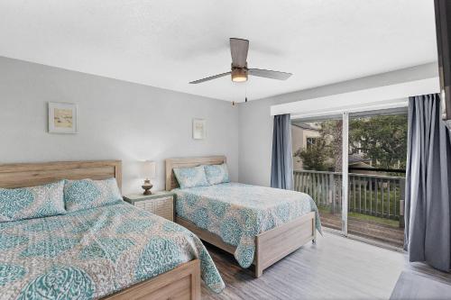 a bedroom with two beds and a balcony at Fulton Beach Condos in Rockport