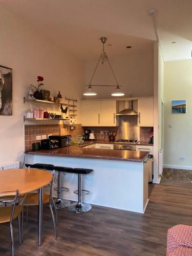 a kitchen with a counter and some tables and chairs at Stunning 2 bedroom apartment in Glasgow