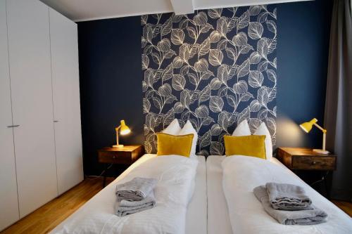 een slaapkamer met een bed met witte lakens en gele kussens bij 4-Room Luxury Apartment - close to Central Station, free parking, kitchen in Leipzig