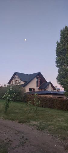a house sitting on top of a grass field at Aires del Sur in Dina Huapi