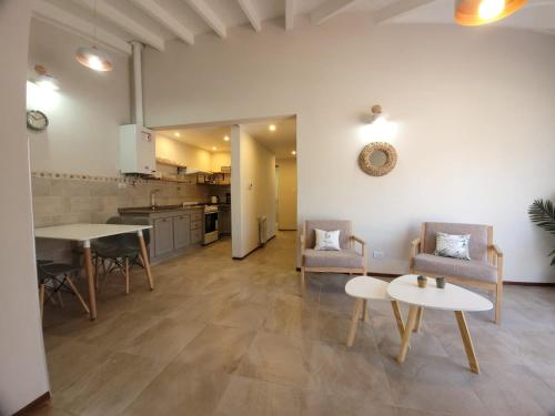 ein Wohnzimmer mit einem Tisch und Stühlen sowie eine Küche in der Unterkunft Aires del Sur in Dina Huapi
