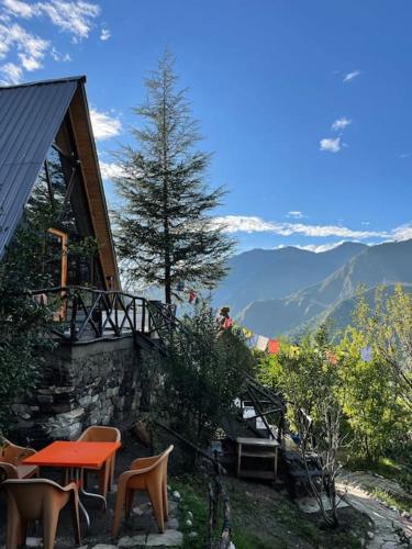 a house with a table and chairs on a mountain at Himalayan Manor A-Frame House in Sainj