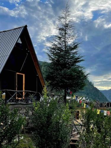 a house with a tree in front of it at Himalayan Manor A-Frame House in Sainj