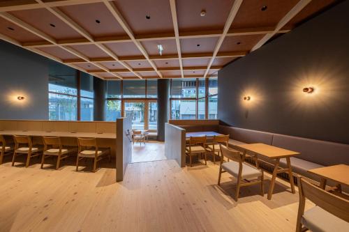 a restaurant with wooden tables and chairs and windows at Onn nakatsugawa in Nakatsugawa