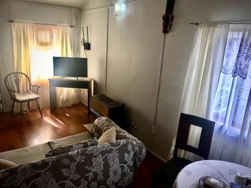 a living room with a couch and a table and window at Cabañas Esmeralda con Desayuno in Punta Arenas