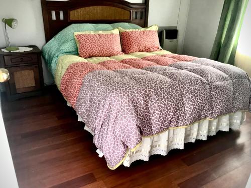 a bed with pillows and a blanket on it at Cabañas Esmeralda con Desayuno in Punta Arenas