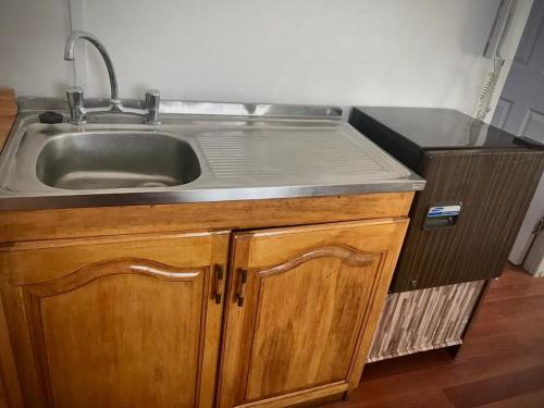 a kitchen sink with a stainless steel counter top at Cabañas Esmeralda con Desayuno in Punta Arenas