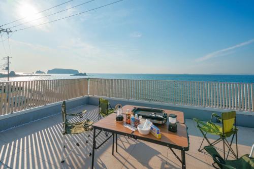 a balcony with a table and chairs and the ocean at Ryushima Ocean View Besso - Vacation STAY 13427 in Minamiboso