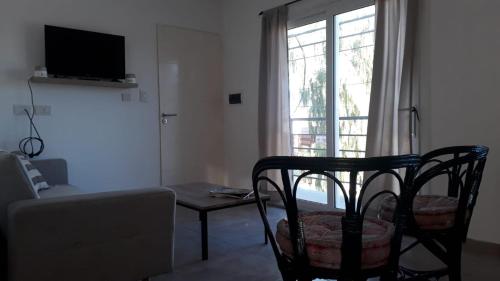 sala de estar con silla y ventana en Departamento temporal Tandil en Tandil