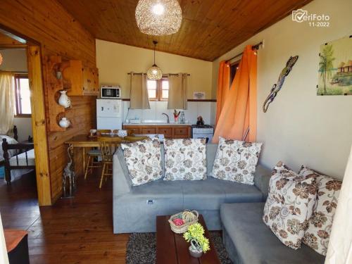 sala de estar con sofá azul y cocina en Un Sueño, en Punta del Diablo