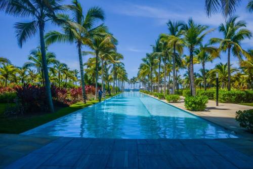 a swimming pool lined with palm trees on a resort at BONITO DEPARTAMENTO PENINSULA IXTAPA 02 Recámaras in Ixtapa