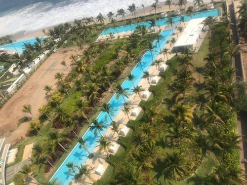 an aerial view of a resort swimming pool with palm trees at BONITO DEPARTAMENTO PENINSULA IXTAPA 02 Recámaras in Ixtapa