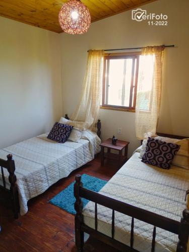 a bedroom with two beds and a window at Un Sueño in Punta Del Diablo