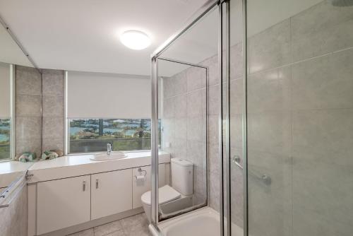a bathroom with a shower and a toilet and a sink at 2 bedrooms apartment on the beach and with air conditioning and pool in Buddina