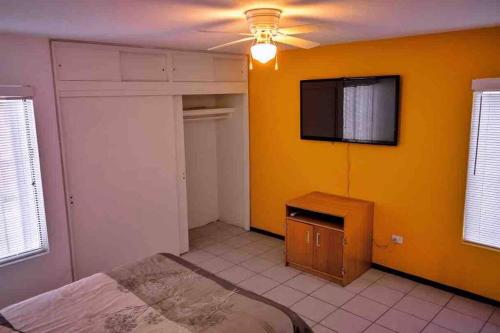 華雷斯城的住宿－Departamento con Amplia Terraza en Excelente Zona，一间卧室设有一张床和黄色的墙壁
