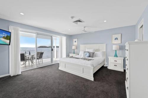 una camera con letto e vista sull'oceano di Waterfront Wonderland 41 Foreshore Dr stunning house with a lift linen Wi Fi and ducted air conditioning a Salamander Bay