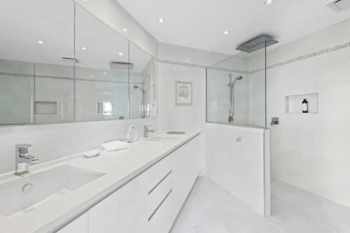 un bagno bianco con 2 lavandini e una doccia di Waterfront Wonderland 41 Foreshore Dr stunning house with a lift linen Wi Fi and ducted air conditioning a Salamander Bay