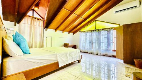 a bedroom with a bed and a large window at Masfalhi View Inn in Felidhoo