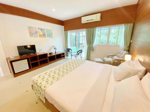 1 dormitorio con 1 cama grande y TV en Phuket Jungle Experience Resort en Karon