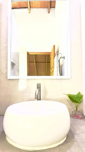 a white sink in a bathroom with a mirror at Masfalhi View Inn in Felidhoo