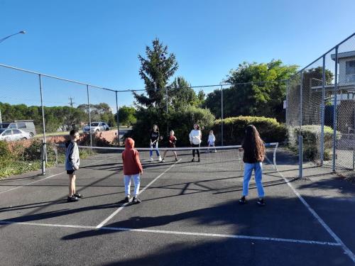 a group of people playing tennis on a tennis court at Abbotswood Motor Inn in Geelong