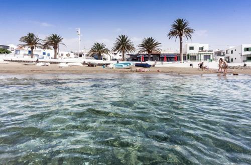 Blick auf einen Strand mit Palmen und Wasser in der Unterkunft Luxury Beach Apartments Diama in Playa Honda