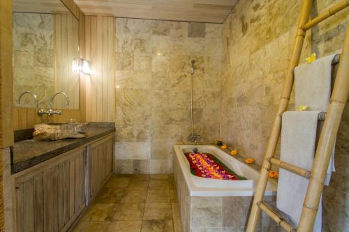 La salle de bains est pourvue d'une baignoire et d'un lavabo. dans l'établissement Sarin Ubud Suites by Pramana Villas, à Ubud