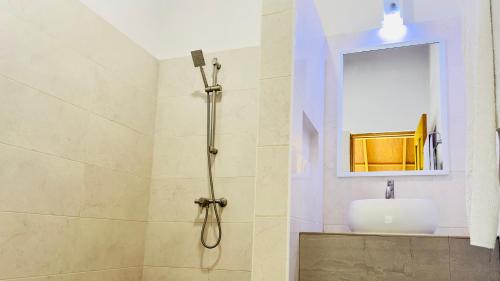 a bathroom with a shower with a sink and a mirror at Masfalhi View Inn in Felidhoo