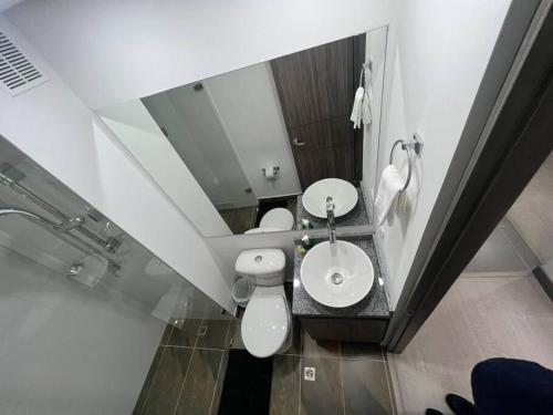 a bathroom with a toilet and a sink and a mirror at Aparta estudio central con ascensor 403 in Bogotá