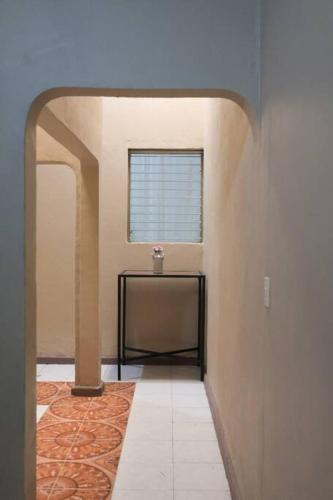 a hallway with a table and a window at Espacio Demeter, Relájate en el centro de Comayagua in Comayagua