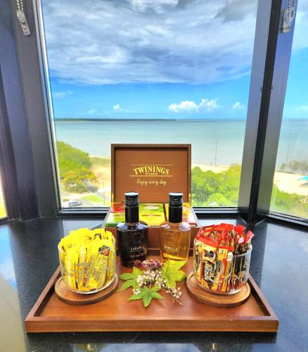 a tray with drinks on a table in front of a window at Cairns Ocean View Apartment in Cairns